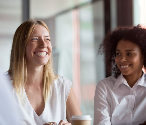 Happy young businesswoman coach mentor leader laughing at group meeting